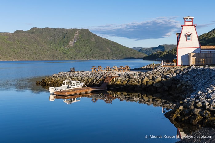 A lighthouse and boat on the shore of Bonne Bay in Gros Morne National Park.