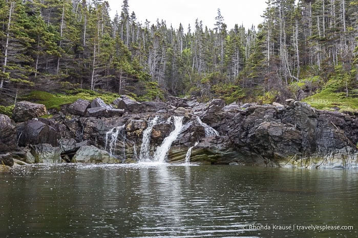 Small waterfall flowing over rocks into Bonne Bay.