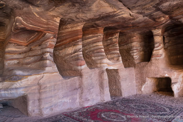 Carpets and rock formations inside a tomb.