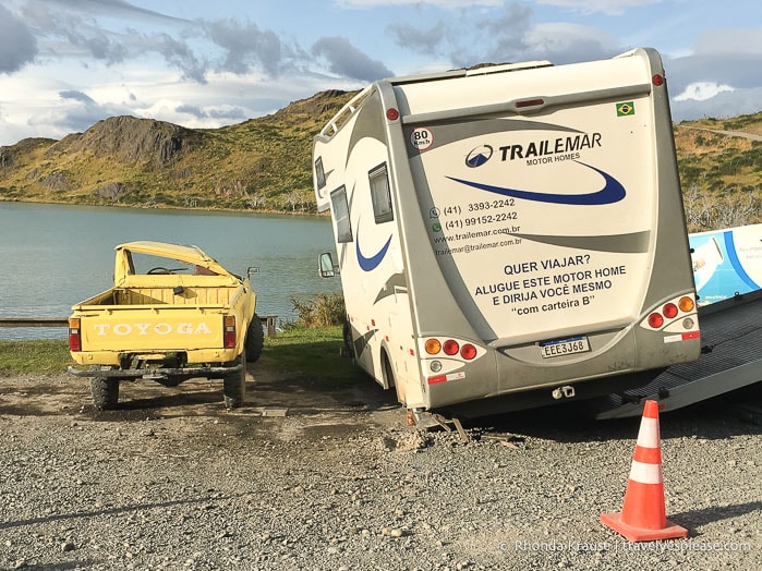 RV being pulled off a small yellow truck with a crushed roof.