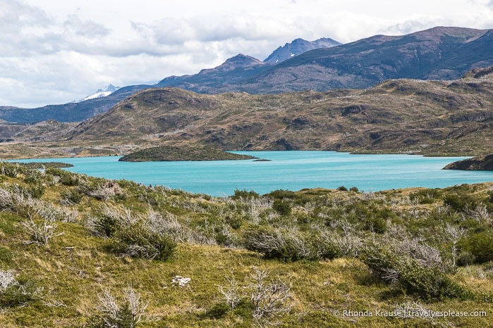 Turquoise lake surrounded by hills.