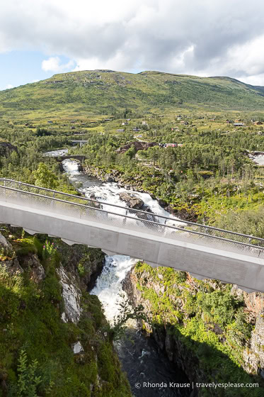 Step bridge crossing the river with a hill in the background.