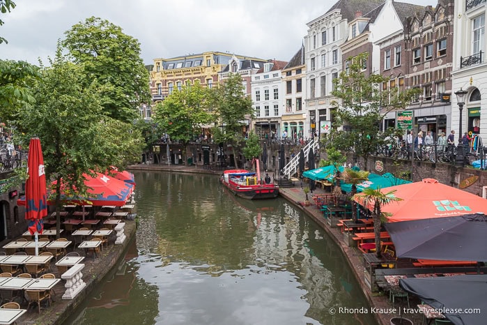 Restaurant tables and buildings beside a canal.