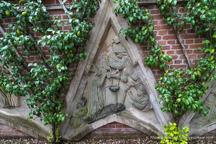 Sculpture on a brick wall in Flora's Hof.