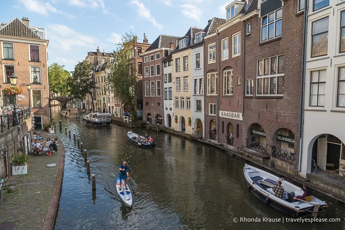 Boats and a paddle boarder on a canal.